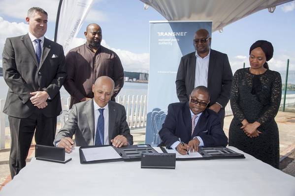 Frente: Gianluca Suprani (izquierda, de la Terminal de cruceros KwaZulu) y Siyabonga Gama (derecha, consejero delegado del grupo Transnet) sellan el acuerdo del operador terminal para la nueva terminal de cruceros de Durban, flanqueada por (espalda, izquierda a derecha) Ross Volk, Nkululeko Mchunu, Moshe Motlohi (COO interino de Transnet National Ports Authority) y Shulami Qalinge (Directora ejecutiva de Transnet National Ports Authority).