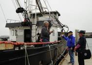 Coast Guard Auxiliarists walk the docks of Hyde Street Pier in San Francisco offering a free safety examination to a crab fisherman prior to the start of crab season, November 2012. (U.S. Coast Guard photo by Pamela J. Boehland)