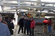 Coast Guard Sector Northern New England’s commander, Capt. James McPherson (3rd from left), poses with members of the Ocean Renewable Power Company (ORPC) in front of the barge Energy Tide 2 March 2, 2010. The Energy Tide 2 will be used to generate green, renewable energy to be used at Coast Guard Station Eastport during a testing phase for ORPC. Coast Guard photo by Petty Officer 1st Class Rich Cherkauer.