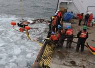 USCG crewmembers used an oil-skimming device to recover peat moss, acting as a substitute for spilled oil, near Mackinac Island.