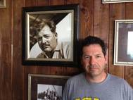 ohn Hemingway poses next to photo of grandfather Ernest Hemingway at the Bimini Big Game Club Resort.