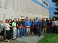 Joined by Jet Edge employees and local business and government leaders, Jet Edge President Jude Lague cuts a ribbon to mark Jet Edge’s 30th anniversary in the waterjet industry. The ribbon cutting was coordinated by the I-94 West Chamber of Commerce. Photo courtesy I-94 West Chamber of Commerce.