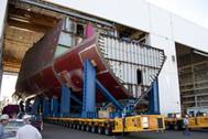 Maine shipyard workers guide one of four "Ultra Units" for DDG 1000, the lead ship of the Zumwalt-class of guided missile destroyers. Work on DDG 1000 is now over 50% complete.