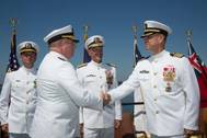 Rear Adm. Michael Jabaley (second from left) shakes hands with Rear Adm. (select) Moises DelToro (right) as they pass command of the Naval Undersea Warfare Center from Jabaley to DelToro. Looking on are Vice Adm. William Hilarides, commander of the Naval Sea Systems Command (second from right) and Lieut. Philip Carson, Naval Station Newport chaplain (left).