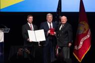 Matt Mulherin (center) accepts the Fleet Admiral Chester W. Nimitz Award from Alan Kaplan (left), national president of the Navy League of the United States, and Dr. J.P. “Jack” London, executive chairman and chairman of the board of CACI International Inc., on Monday afternoon in National Harbor, Maryland. Photo by Ashley Cowan/HII