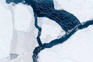 The wind has opened a lead between ice floes. As the white streaks reveal, the water surface is freezing again immediately. The streaks occur when the wind drifts loose ice crystals. Photo IceCamStefan Hendricks, Alfred-Weg