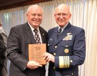 2012 photo of US Coast Guard Commandant Robert J. Papp, Jr. presenting AdvanFort President William H. Watson a plaque for service to the Amver program and Amver Logo