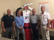 New Resolve Partners Chauncey Naylor (director of the Resolve Academy), Stacy Payne (Resolve) and Glyn Day and Neil Cooper both with Fire Ranger.
The Large Fire Extinguisher is called Big Red. (Image: Resolve Marine)
