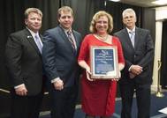 Suzanne Beckstoffer accepts the Virginia Peninsula Engineer of the Year award from (from left to right) Gary Fuller, president of the Peninsula Engineers Council (PEC); Scott Opdyke, representative from the Society of Naval Architects and Marine Engineers (SNAME), the society that nominated Beckstoffer; and Ken Hoffman, the PEC Engineer of the Year committee chair. (Photo by Dar Mook/HII)