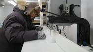 Using a special band saw, SDSU chemistry professor Jihong Cole-Dai slices off a piece of ice core from Western Antarctica. The specimens are stored at -4 degrees Fahrenheit in the university's Ice Core and Environmental Che