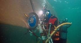 Hydrex diver positioning the blade cutting tool over the propeller blade. © Hydrex