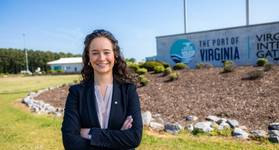 Finley Stoops stands in front of Port of Virginia sign. Imiage courtesy ODU