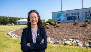 Finley Stoops stands in front of Port of Virginia sign. Imiage courtesy ODU