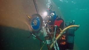 Hydrex diver positioning the blade cutting tool over the propeller blade. © Hydrex