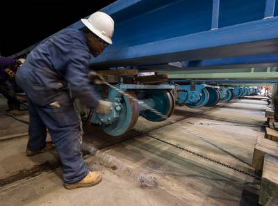 Alexander Manning pulls a piece of track into position at Newport News Shipbuilding under a transfer car for the submarine John Marner (SSN 785). Photo by Chris Oxley