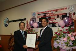 ClassNK Executive Vice President Koichi Fujiwara (L) presents NYKSM CEO Tomoyuki Koyama (R) with certificate.