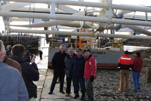 Coast Guard Sector Northern New England’s commander, Capt. James McPherson (3rd from left), poses with members of the Ocean Renewable Power Company (ORPC) in front of the barge Energy Tide 2 March 2, 2010. The Energy Tide 2 will be used to generate green, renewable energy to be used at Coast Guard Station Eastport during a testing phase for ORPC. Coast Guard photo by Petty Officer 1st Class Rich Cherkauer.