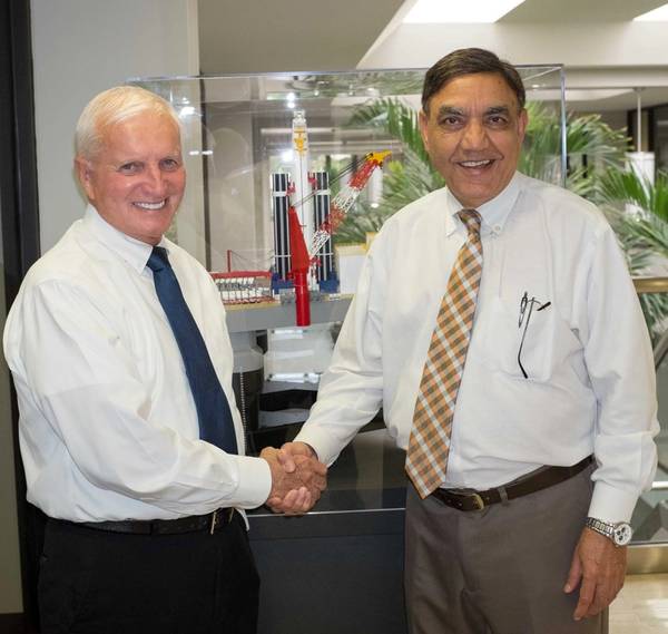 Bob Fogal, left, accepting congratulations from Ramesh Maini