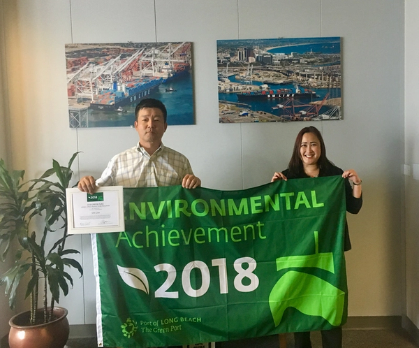 Photo caption: Henry Pak,  General Manager of Terminal Management, USA, at SM Line Corp., was recently presented with a Green Flag by Wendy Fung, Business Development Manager, Exports, at the Port of Long Beach. SM Line was recognized for voluntarily slowing its vessels to 12 knots or less within 40 miles of the Port.(Photo: Port of Long Beach)