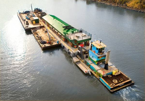 The M/V River Cleanup II pushes Living Land & Waters' floating classroom "Teamwork" en route to New Orleans.