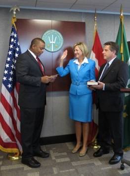 U.S. Secretary of Transportation Anthony Foxx swearing in Betty Sutton as Administrator of the Saint Lawrence Seaway Development Corporation. Her husband Doug Corwon holds their family Bible.
