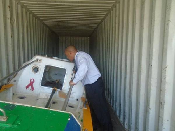Victor Mooney of Queens, New York looks at the Spirit of Malabo inside a shipping container at the Haitian Coast Guard base in Cap Haitian today.