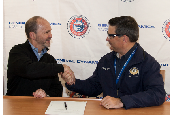 Anthony Chiarello, president and CEO of TOTE, and Kevin Graney, vice president and general manager at General Dynamics NASSCO, shake hands following delivery signing ceremony aboard the Perla Del Caribe at the NASSCO shipyard. (Photo: General Dynamics NASSCO)