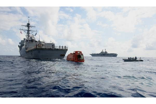 USS Bainbridge tows the lifeboat from the Maersk Alabama to the USS Boxer, in background, to be processed for evidence after the rescue of Capt. Phillips. Phillips was held captive by suspected Somali pirates in the lifeboat in the Indian Ocean after a failed hijacking attempt off the Somali coast. (U.S. Marine Corps photo by Megan E. Sindelar)