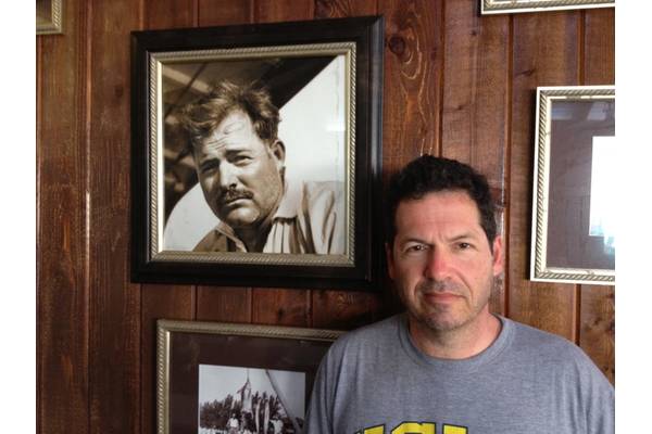 ohn Hemingway poses next to photo of grandfather Ernest Hemingway at the Bimini Big Game Club Resort.
