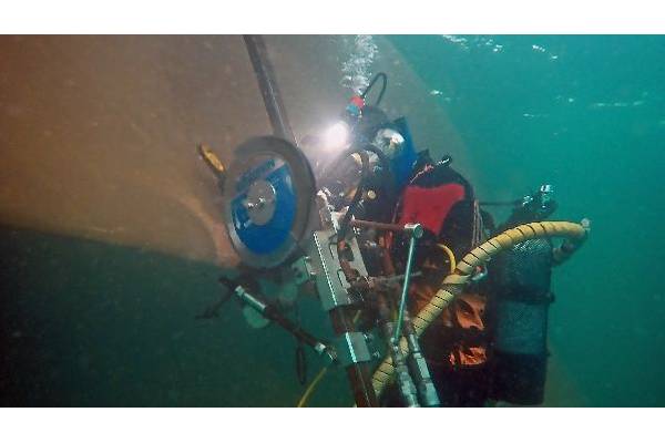 Hydrex diver positioning the blade cutting tool over the propeller blade. © Hydrex