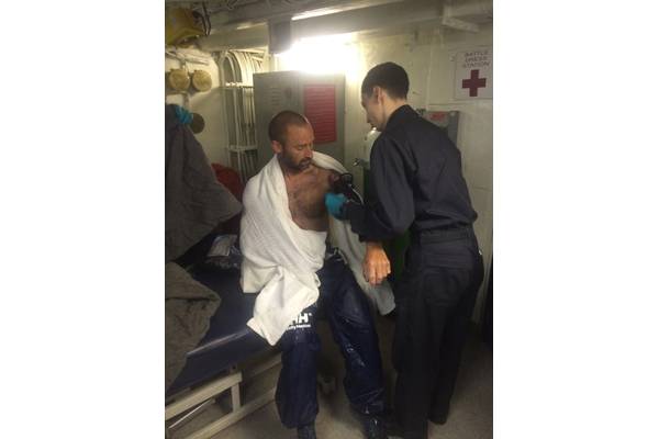 A rescued mariner has his vital signs checked in a battle dress station by a hospital corpsman aboard the aircraft carrier USS Dwight D. Eisenhower after his vessel became disabled off the coast of Florida. (U.S. Navy photo by John Osborne)
