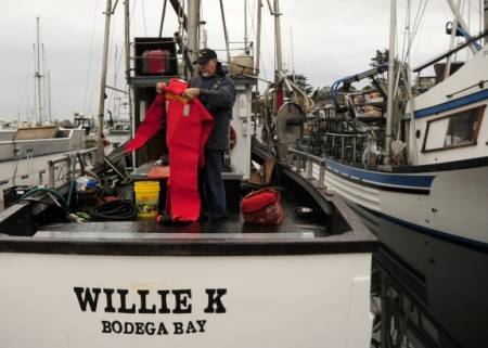 Ronald Kram, a Coast Guard Auxiliarist, inspects an immersion suit aboard the Willie K, a crab vessel moored in Spud Point Marina in Bodega Bay, November 8, 2012. (U.S. Coast Guard photo by Pamela J. Boehland)