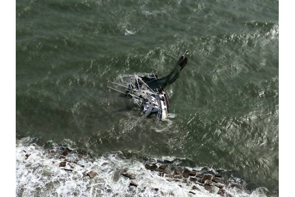 A shrimp boat is grounded on South Galveston Jetty after three fisherman aboard were rescued by the Coast Guard. (U.S. Coast Guard photo by Air Station Houston)