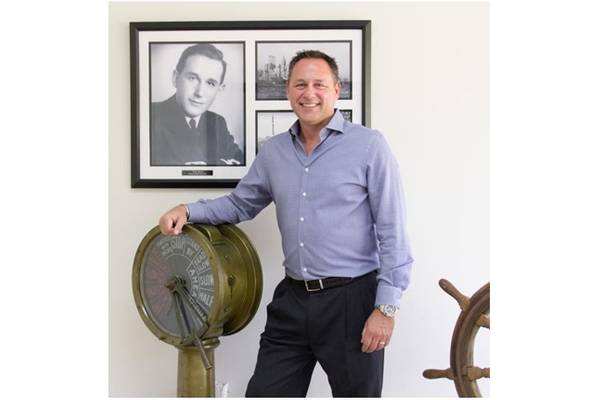 World Wide Metric CEO George Contos stands in front of a picture of his father Constantinos Contos, who founded the company in 1970. George took over as CEO in 2000 and has grown the business significantly since taking the helm. (Photo: World Wide Metric)